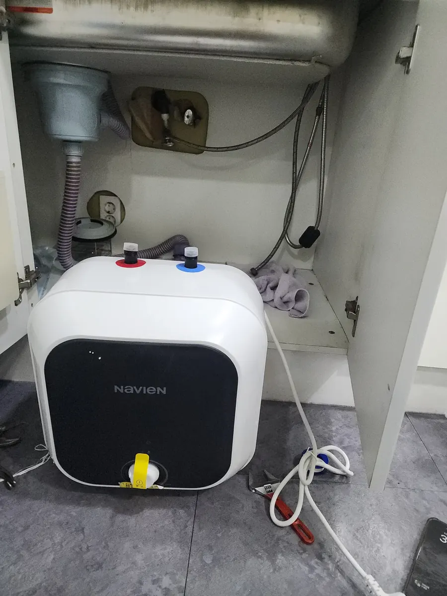 저장식 온수기 설치 — 싱크대 하부에 놓은 새 온수기